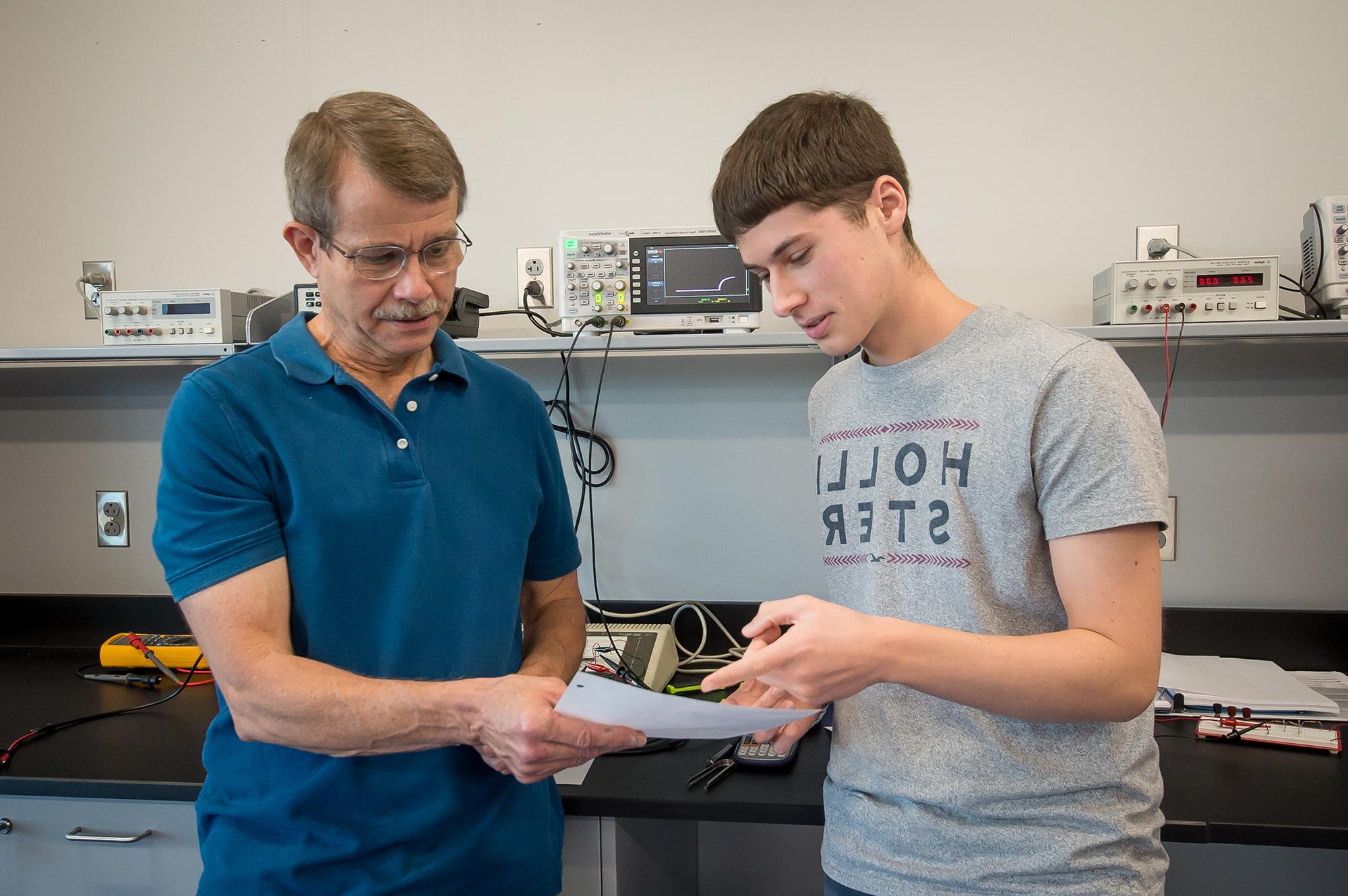 An engineering professor showing his student a question on an assignment