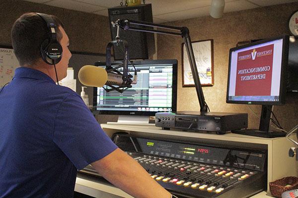 Student using the soundboard in the studio in Davis Hall on Vincennes University.