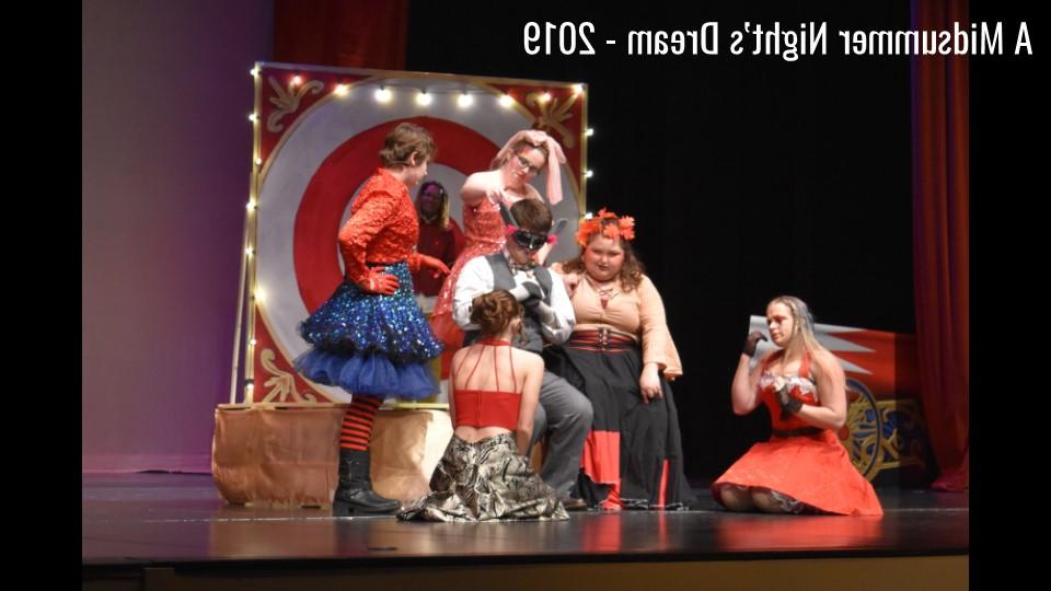 A group of students dressed up in costumes standing around a target