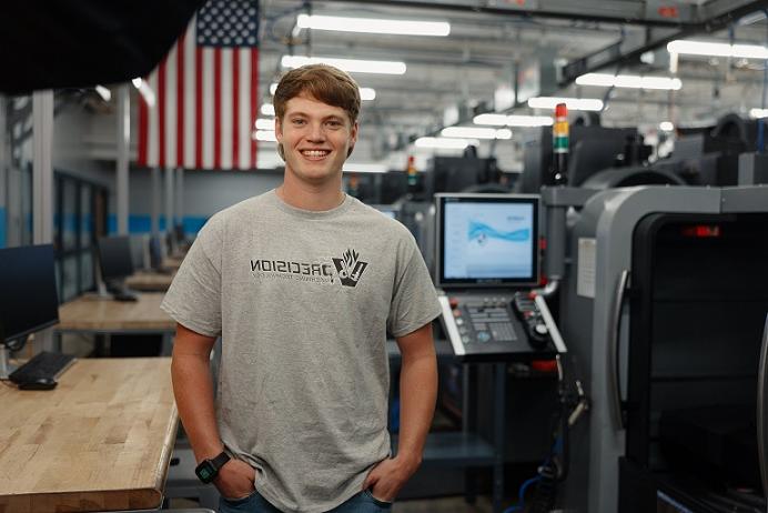 tech/vincennes-university-technology-center-student-smiling-at-camera-standing-next-to-machine